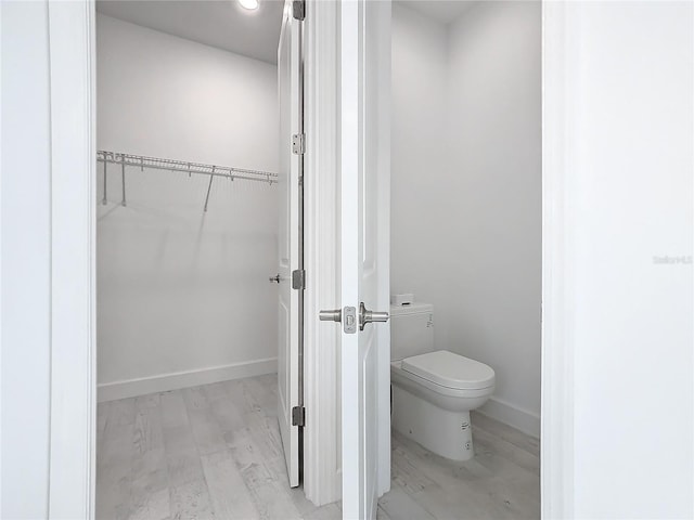 bathroom with hardwood / wood-style floors and toilet