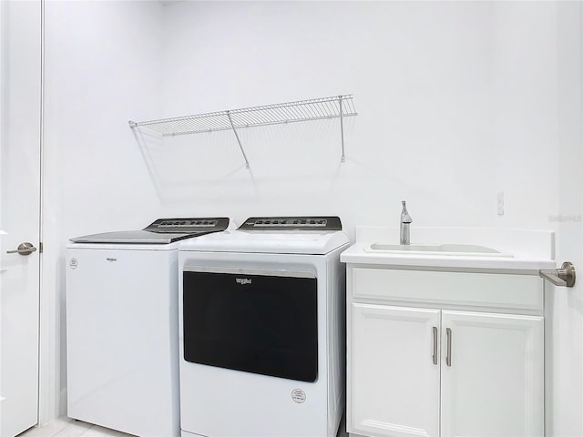 washroom with cabinets, separate washer and dryer, and sink