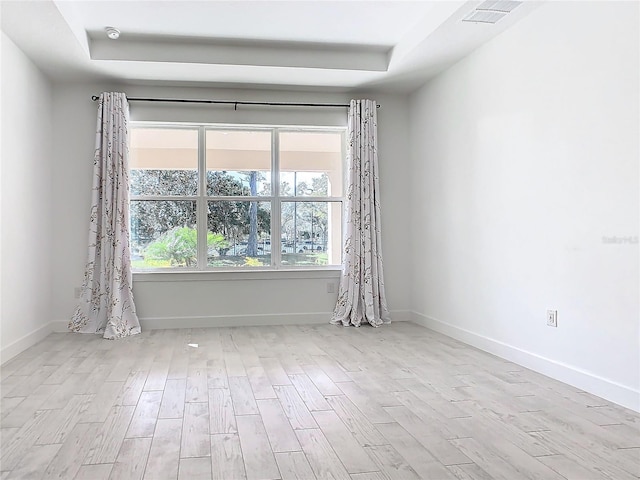 195 Casavista Dr, Kissimmee, FL 34759 - empty room with a tray ceiling, baseboards, visible vents, and wood finished floors