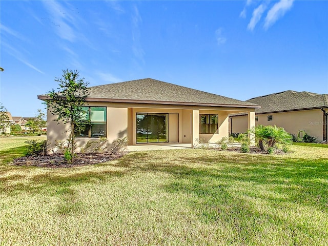 195 Casavista Dr, Kissimmee, FL 34759 - rear view of property with a lawn, stucco siding, roof with shingles, and an attached garage