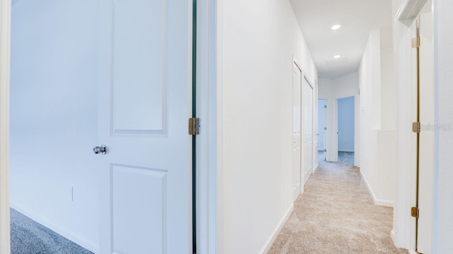 hallway featuring light colored carpet