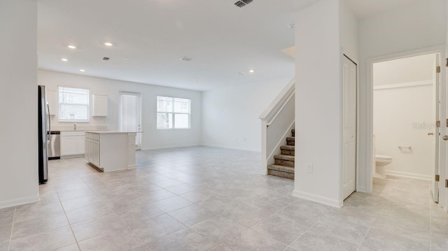 unfurnished living room featuring a wealth of natural light and light tile patterned floors