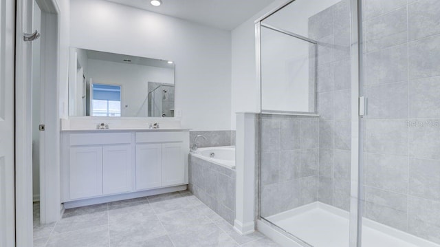 bathroom featuring tile patterned flooring, shower with separate bathtub, and vanity