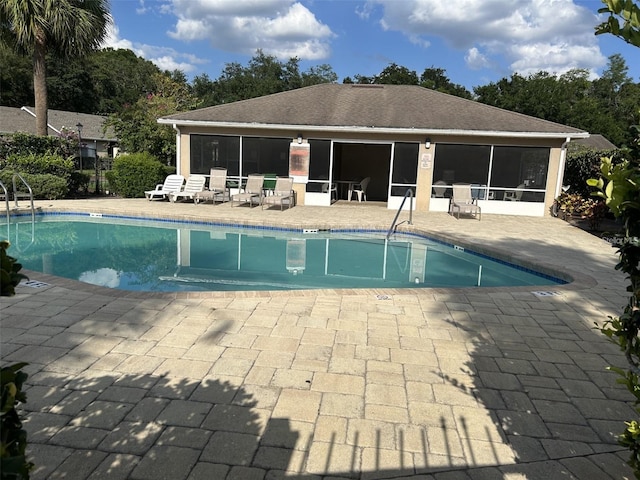 view of swimming pool featuring a patio and a sunroom