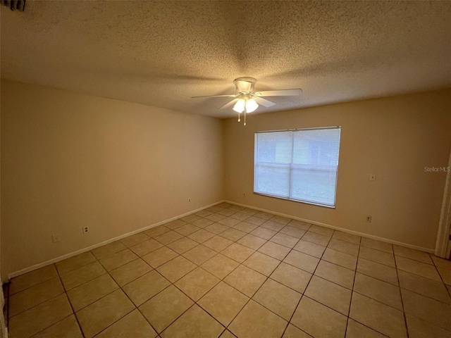 empty room featuring light tile patterned floors, a textured ceiling, and ceiling fan