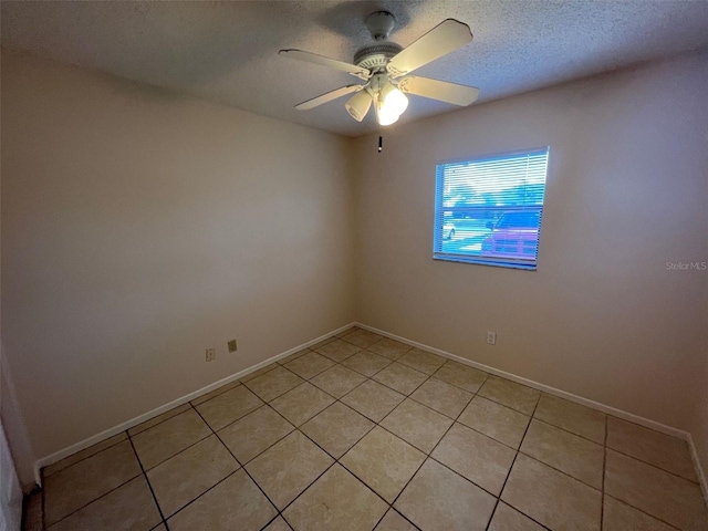 tiled spare room with ceiling fan and a textured ceiling