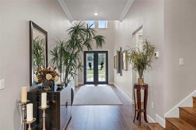 entryway with crown molding, french doors, a textured ceiling, and hardwood / wood-style flooring