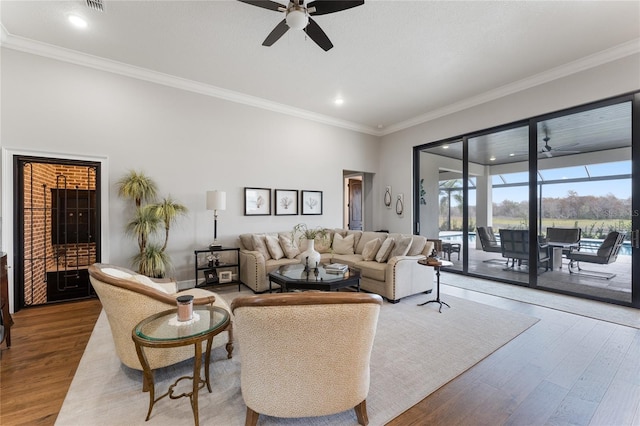 living room with hardwood / wood-style floors, ceiling fan, and crown molding