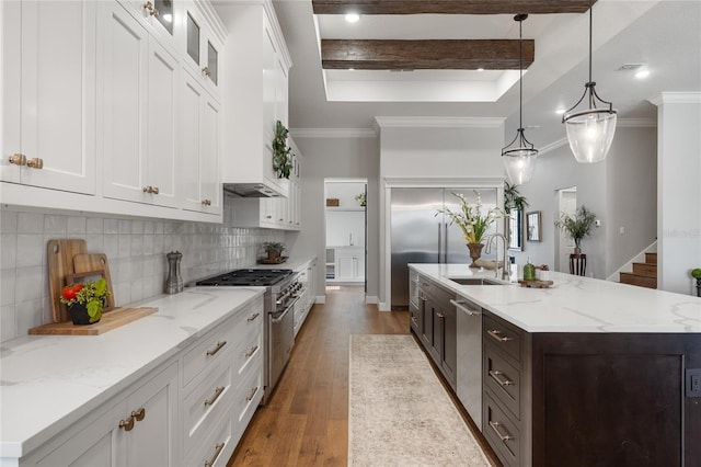 kitchen with stainless steel appliances, beamed ceiling, pendant lighting, white cabinets, and light wood-type flooring