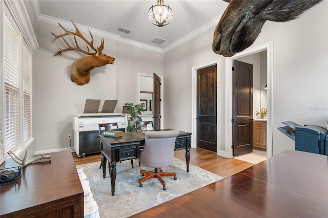 home office with light hardwood / wood-style floors, crown molding, and a notable chandelier