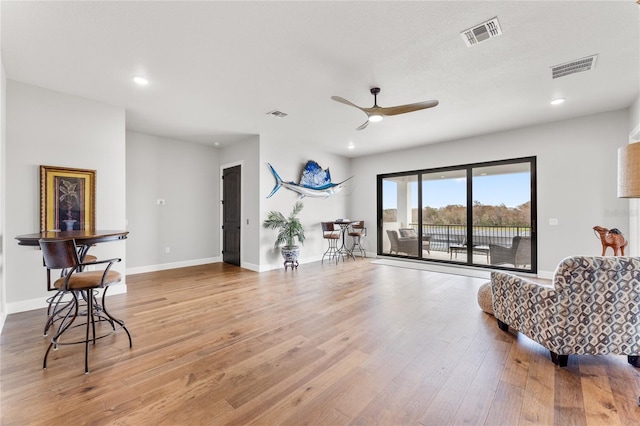 living area featuring ceiling fan and light hardwood / wood-style flooring