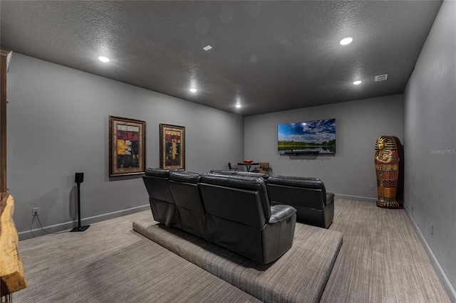 cinema room featuring light colored carpet and a textured ceiling