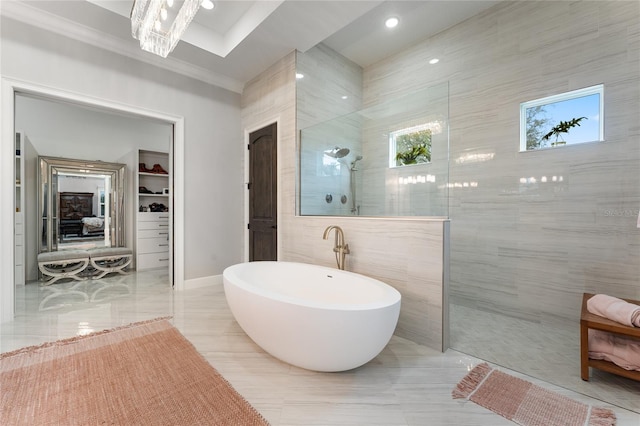 bathroom featuring separate shower and tub, crown molding, a chandelier, and tile walls