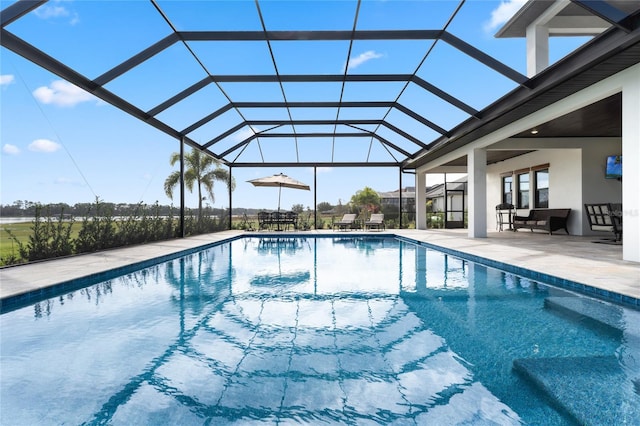 view of swimming pool featuring glass enclosure and a patio area