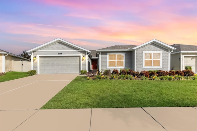 ranch-style home featuring a lawn and a garage