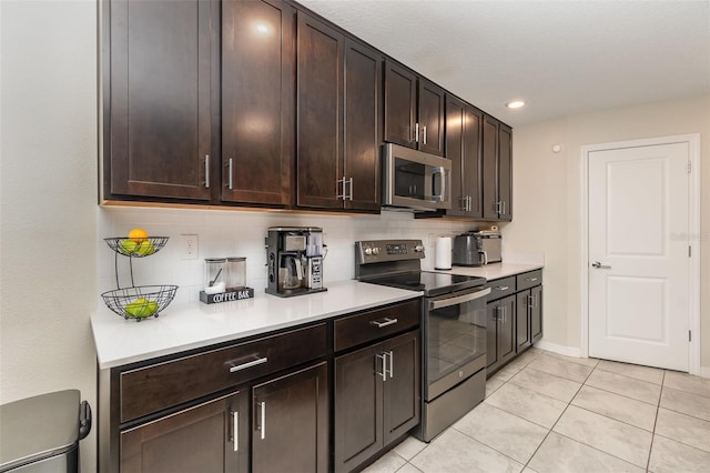 kitchen featuring appliances with stainless steel finishes, dark brown cabinetry, tasteful backsplash, and light tile patterned flooring