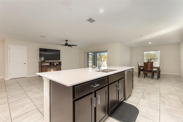 kitchen featuring ceiling fan, dishwasher, sink, a center island with sink, and dark brown cabinets