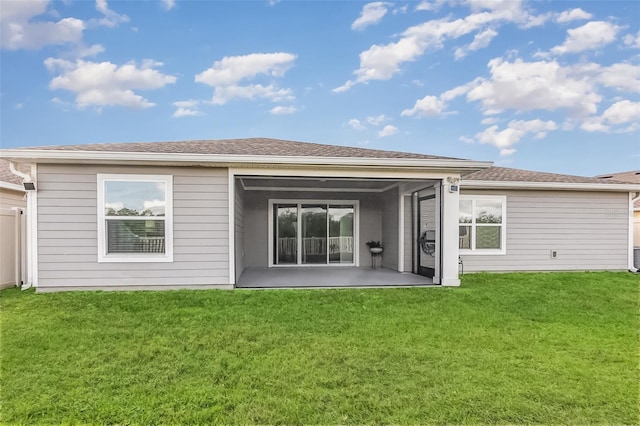 rear view of property with a yard and a patio area