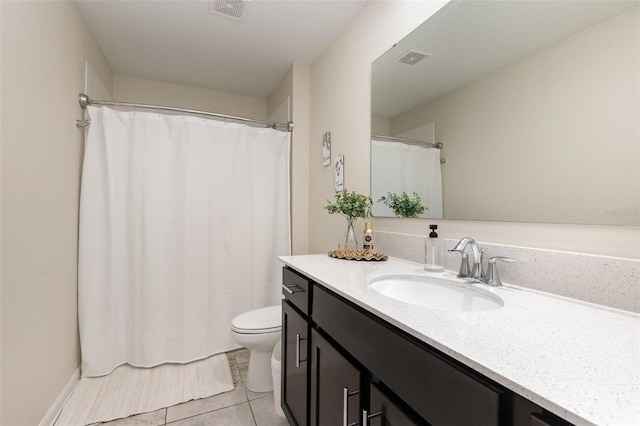 bathroom with tile patterned flooring, vanity, and toilet