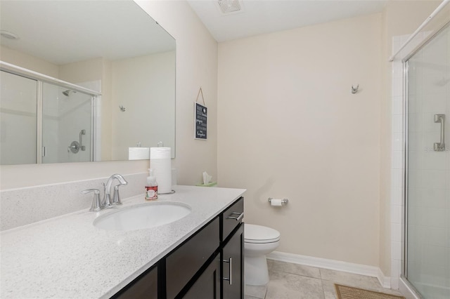 bathroom with tile patterned floors, a shower with door, vanity, and toilet