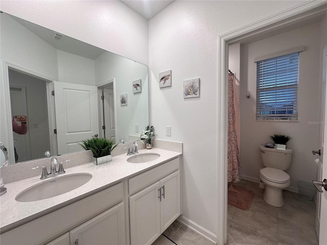 bathroom with tile patterned floors, vanity, and toilet