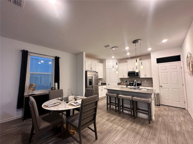 dining space featuring hardwood / wood-style flooring and sink