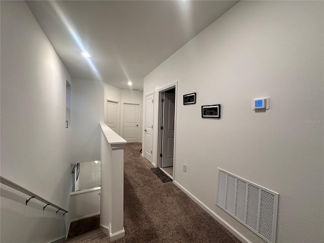 corridor featuring dark colored carpet