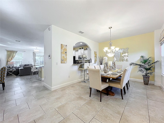 dining space with light tile patterned flooring and a chandelier