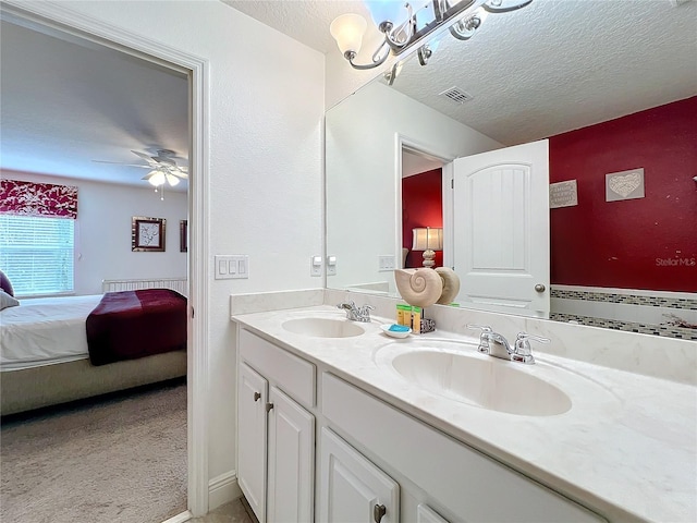 bathroom featuring vanity, a textured ceiling, and ceiling fan