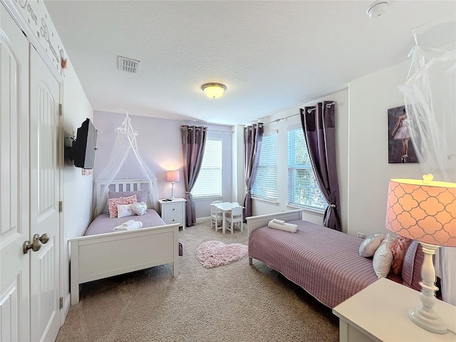 carpeted bedroom featuring a textured ceiling