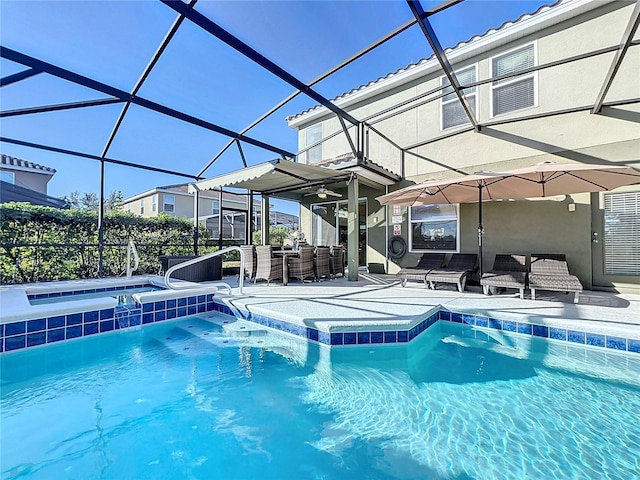 view of pool featuring glass enclosure, a patio area, an outdoor bar, and an in ground hot tub