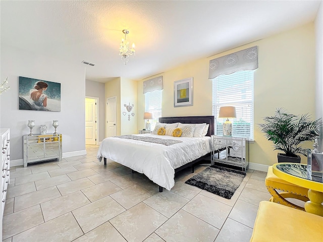 tiled bedroom with a chandelier and a textured ceiling