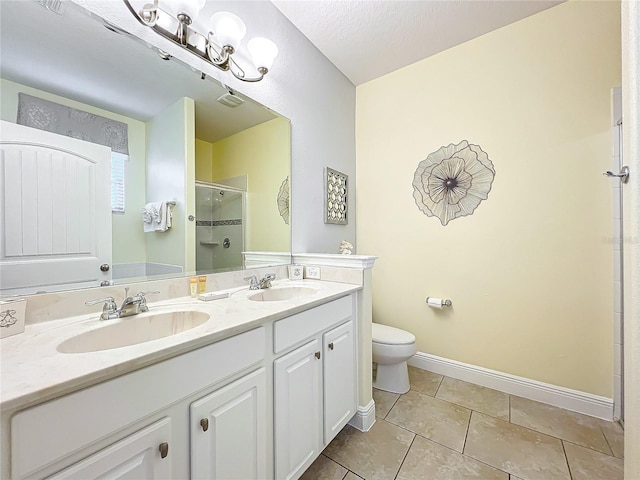 bathroom with tile patterned floors, vanity, a textured ceiling, toilet, and a shower with shower door