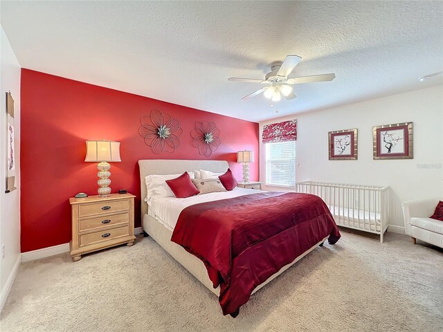 bedroom with carpet, ceiling fan, and a textured ceiling