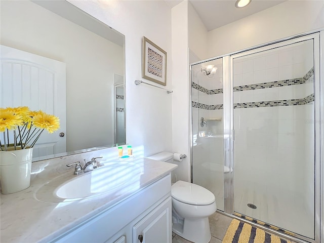 bathroom with tile patterned floors, vanity, toilet, and a shower with shower door