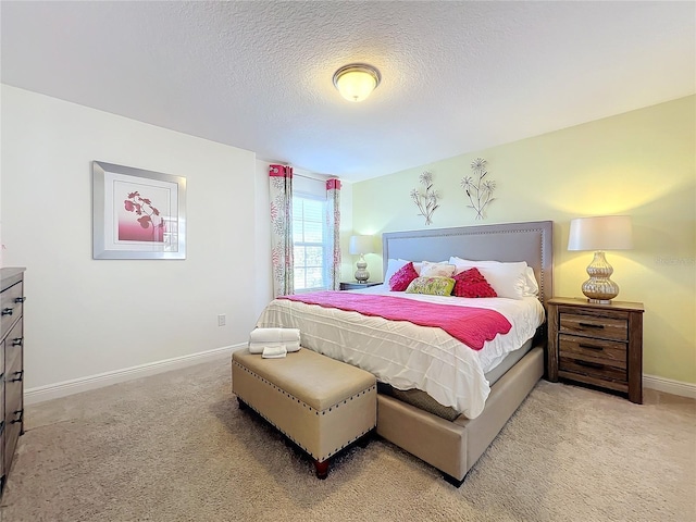 bedroom featuring light colored carpet and a textured ceiling