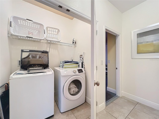 clothes washing area featuring washer and clothes dryer and light tile patterned flooring