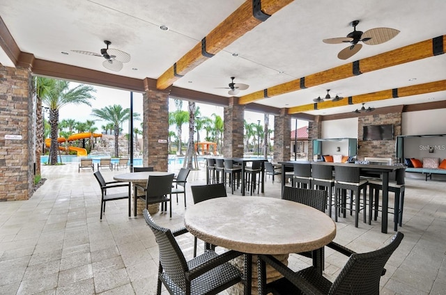 dining area with ceiling fan, plenty of natural light, and beamed ceiling