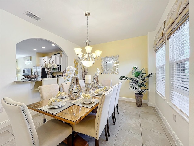 dining area featuring light tile patterned floors and an inviting chandelier