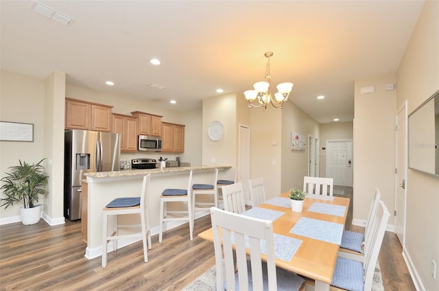 dining room with an inviting chandelier and hardwood / wood-style flooring