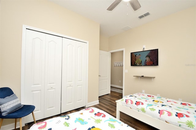 bedroom with ceiling fan, dark wood-type flooring, and a closet