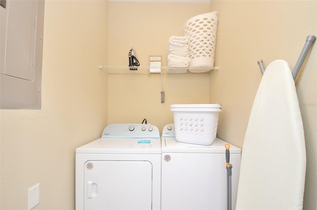 washroom featuring electric panel and washer and clothes dryer