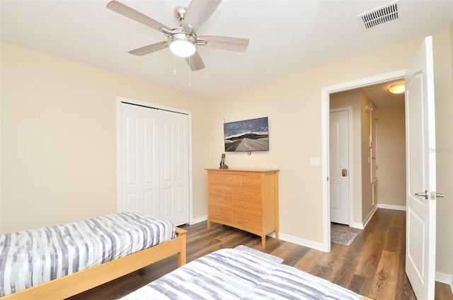 bedroom with ceiling fan, dark hardwood / wood-style floors, and a closet