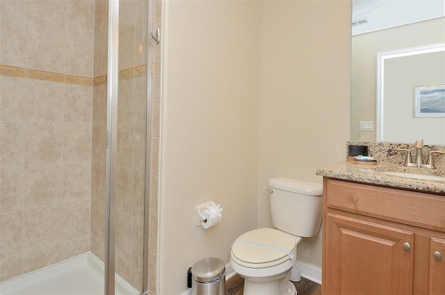 bathroom featuring walk in shower, vanity, and toilet