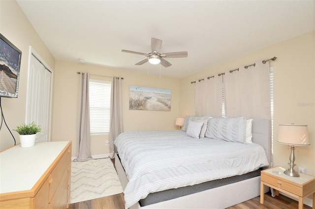 bedroom with a closet, hardwood / wood-style flooring, and ceiling fan