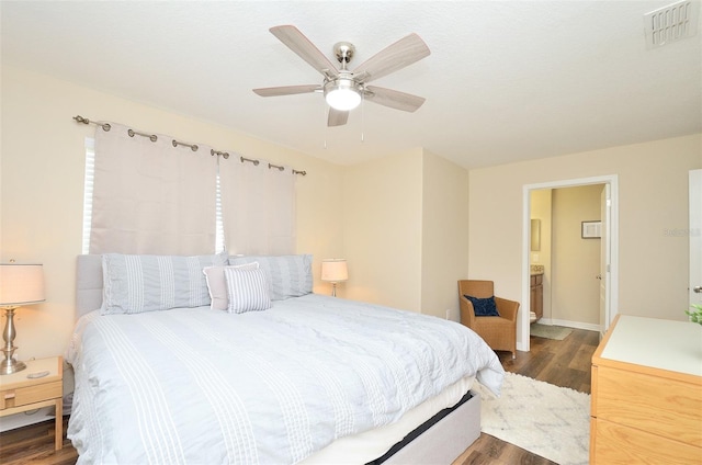 bedroom featuring ceiling fan, ensuite bathroom, and dark wood-type flooring