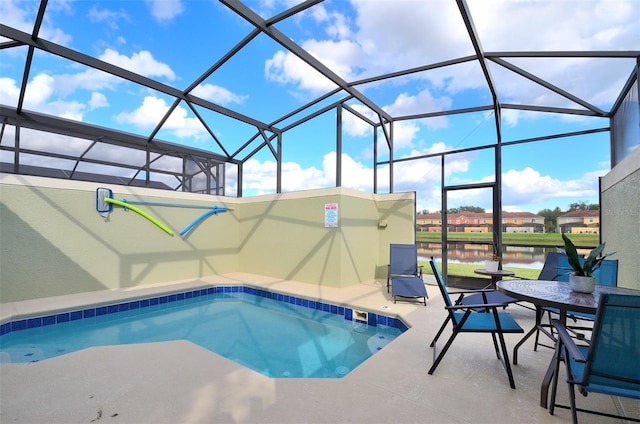 view of pool with a water view, glass enclosure, and a patio area