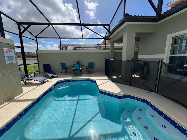 view of swimming pool with a patio area and a lanai