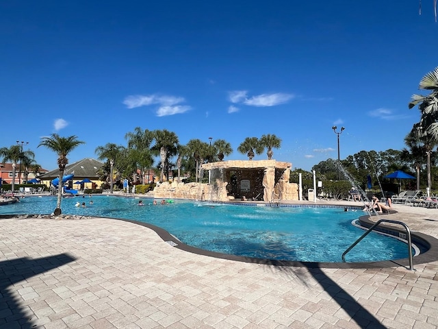 view of pool featuring pool water feature and a patio