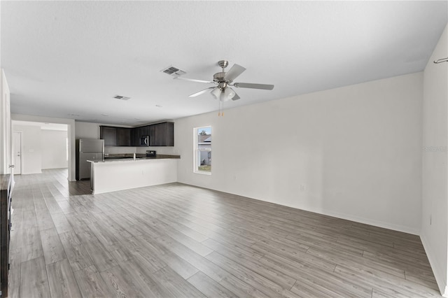 unfurnished living room with light hardwood / wood-style floors and ceiling fan